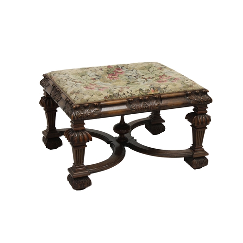 784 - A late 19th century carved oak footstool with a floral fabric upholstered cover, raised on four carv... 