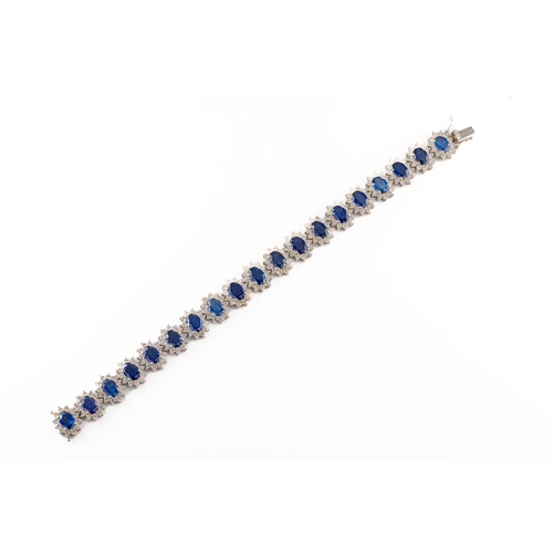 96 - An 18ct white gold sapphire and diamond cluster bracelet the oval cut sapphires approx 18.20cts, sur... 