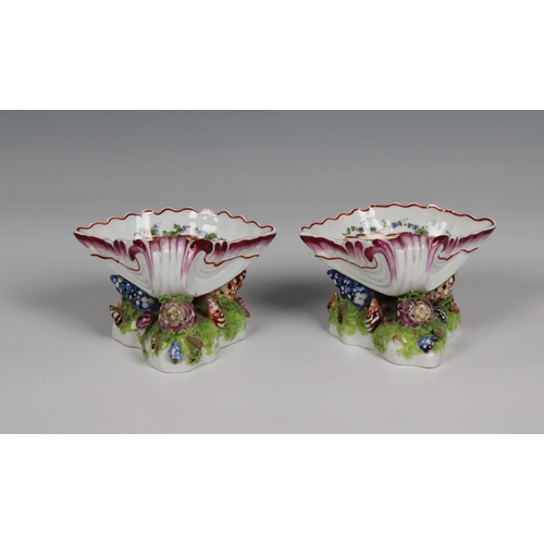 386 - A pair of Bow porcelain sweetmeat stands circa 1765 in the form of upturned scallop shells nestled o... 