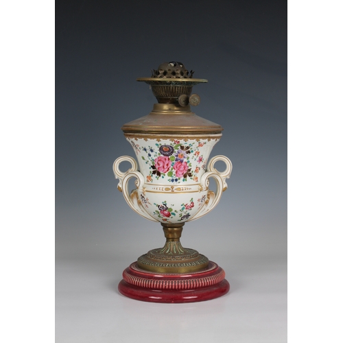 108 - An antique ceramic urn shaped oil lamp decorated with floral sprays, twin foliate scroll handles, to... 