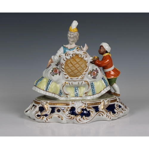 112 - A Meissen style porcelain figural group of a seated lady and servant having blue cross sword mark wi... 