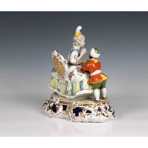 112 - A Meissen style porcelain figural group of a seated lady and servant having blue cross sword mark wi... 