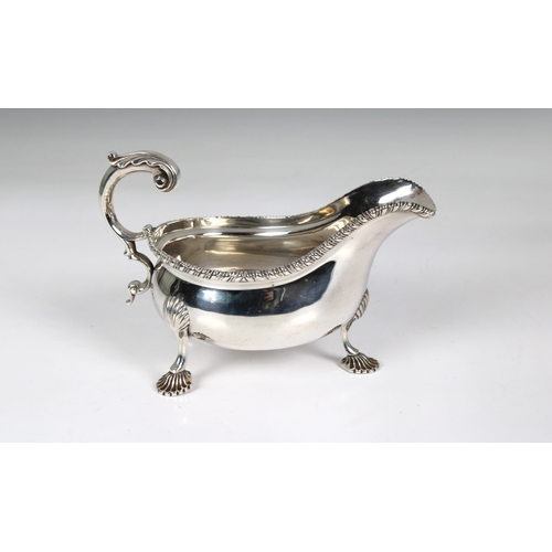 135 - An Edwardian silver sauce boat C.S Harris & Sons Ltd, London, 1908, leaf capped scroll handle, gadro... 