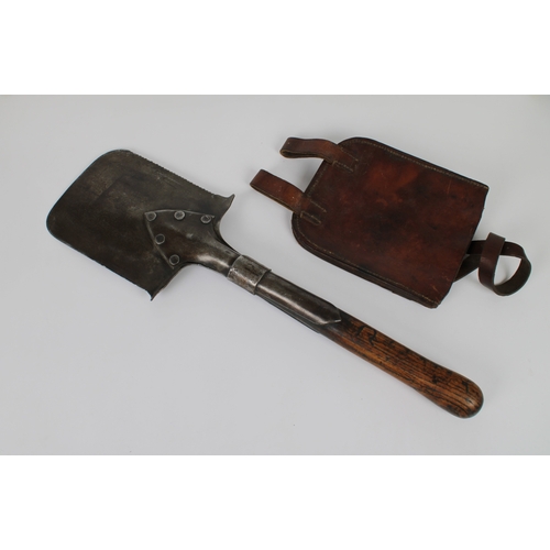 256 - A WWI entrenching tool / spade saw edge, the blade stamped with 1903 and many proof marks, leather s... 