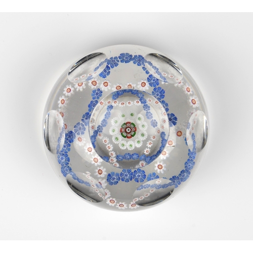 29 - A Baccarat facetted / patterned millefiori glass paperweight the clear glass set with a trefoil garl... 