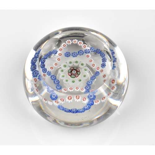 29 - A Baccarat facetted / patterned millefiori glass paperweight the clear glass set with a trefoil garl... 