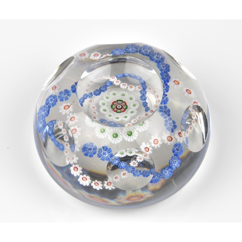 29 - A Baccarat facetted / patterned millefiori glass paperweight the clear glass set with a trefoil garl... 