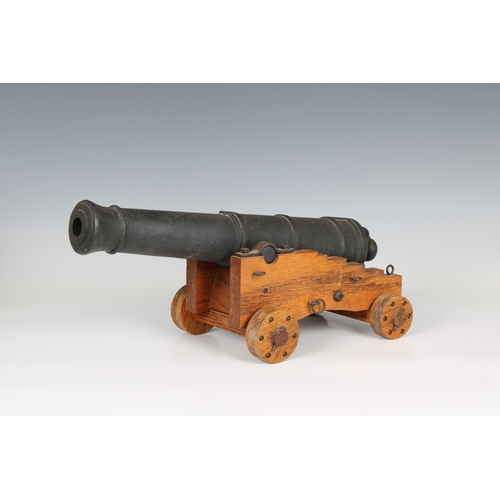 295 - A model cannon with an iron barrel and wooden stepped four wheeled gun carriage barrel 15¾in (40cm.)... 