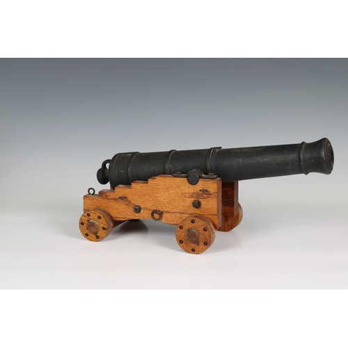 295 - A model cannon with an iron barrel and wooden stepped four wheeled gun carriage barrel 15¾in (40cm.)... 