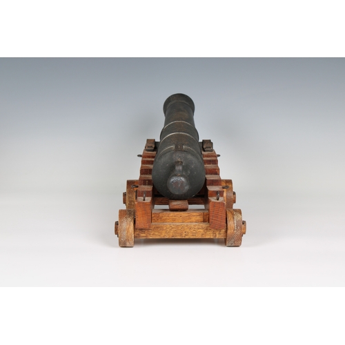 295 - A model cannon with an iron barrel and wooden stepped four wheeled gun carriage barrel 15¾in (40cm.)... 