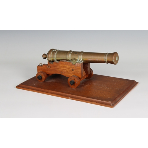 296 - A model cannon with a polished brass barrel and wooden stepped four wheeled gun carriage barrel 9½in... 