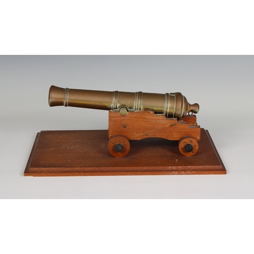 296 - A model cannon with a polished brass barrel and wooden stepped four wheeled gun carriage barrel 9½in... 