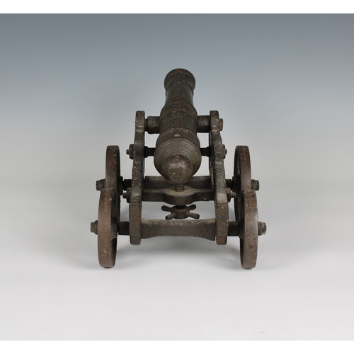 297 - A model cannon with an iron barrel and iron four wheeled gun carriage barrel 13 1/5in. (33.5cm.), bo... 