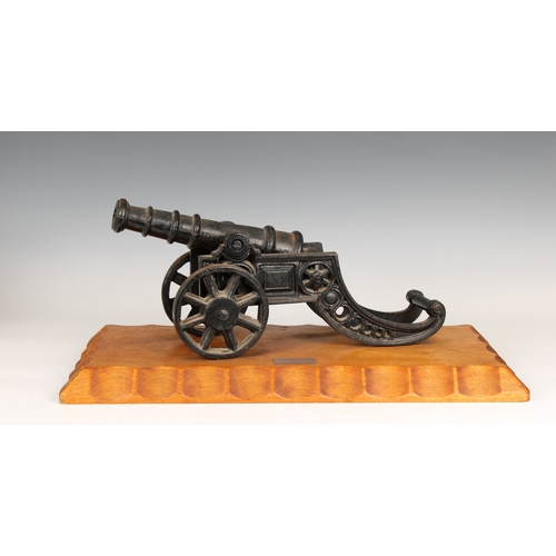 298 - A model cannon with an iron barrel and iron two wheeled gun carriage mounted on a wooden base bearin... 