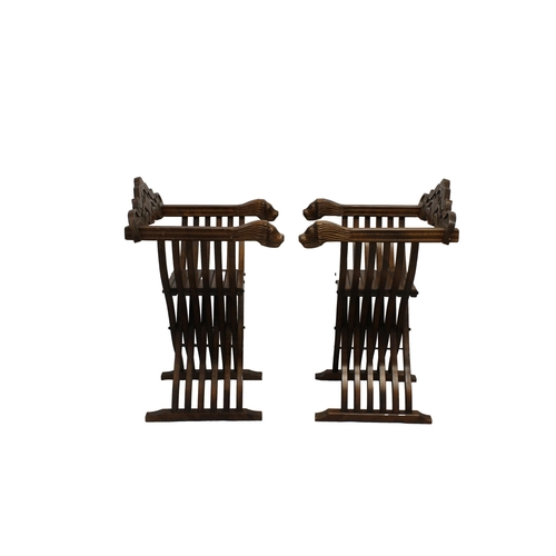 494 - A Pair of Savonarola chairs 20th century, the foliate and scroll carved removable backs over carved ... 