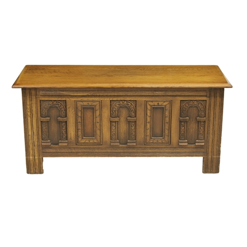 509 - An mid 20th century Old Charm panelled coffer the hinged top over a carved five panel front, raised ... 