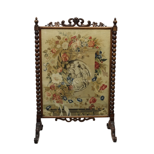 528 - A William IV rosewood tapestry fire screen the pierced foliate crest over bobbin turned columns, on ... 