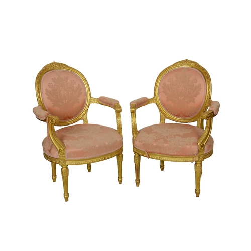 530 - A fine pair of antique French carved and gilded spoon-back fauteuils the backs with ribbon-twist and... 