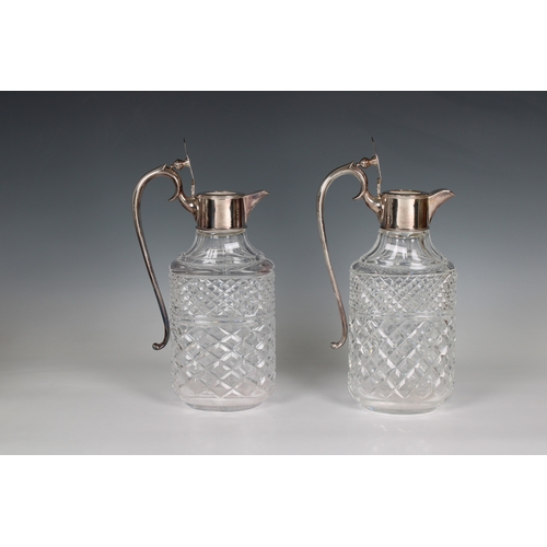 54 - A pair of 20th century clear cut glass decanters / claret jugs with silver plated lids and handles o... 