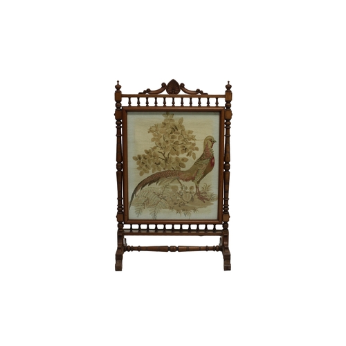 541 - A Victorian oak fire screen with turned column supports and spindle rails above and below a central ... 