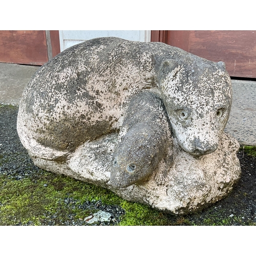 578 - A composite stone figure of a pair of otters 20in. (50.8cm.) long.