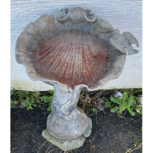 581 - An early 20th century lead bird bath of a cherub supporting a scallop shell a dove perched on the ri... 