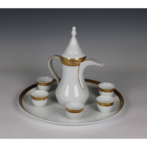 69 - A 20th century Limoges white porcelain and part gilded arabic coffee pot (Dallah) with six associate... 