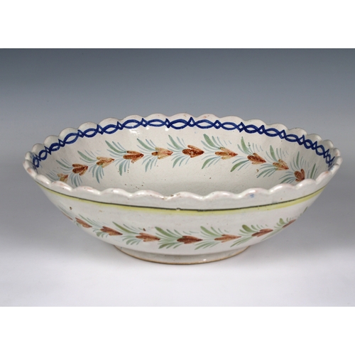 95 - A Quimper French faience bowl depicting a single figure in a field, scalloped rim, monogrammed 'HB' ... 