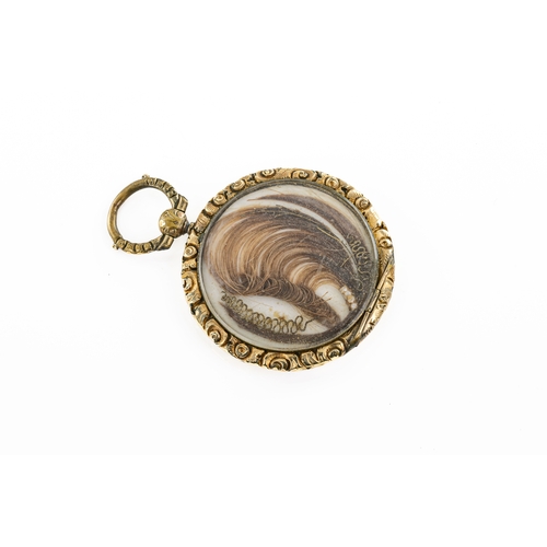 664 - A gold plated locket with hair The gold plated locket engraved, with engine turned decoration and fl... 