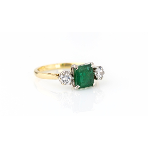 665 - An 18ct yellow gold, emerald and diamond three stone ring the central 6.75 x 6mm. emerald flanked by... 