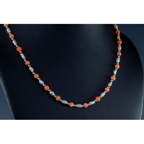 670 - A coral and pearl necklace The necklace with alternating round coral beads, yellow metal beads and p... 