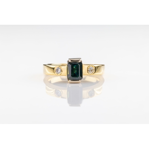 681 - A tourmaline and diamond ring The emerald-cut blue green tourmaline flanked by brilliant cut diamond... 