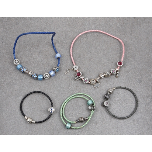 684 - A group of five Pandora leather necklaces and bracelets with silver charms comprising three woven le... 