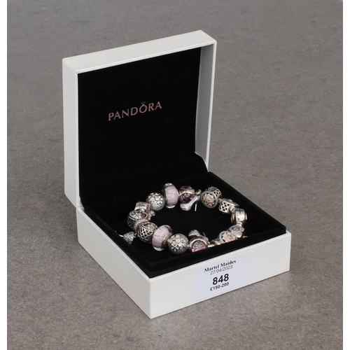 688 - A Pandora bracelet with sixteen silver charms in pink and cream tones, all set with enamel, glass or... 