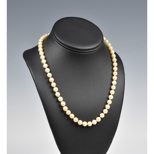 694 - A single strand cultured pearl necklace the evenly sized 7.5mm. pearls with a diamond set 14ct gold ... 