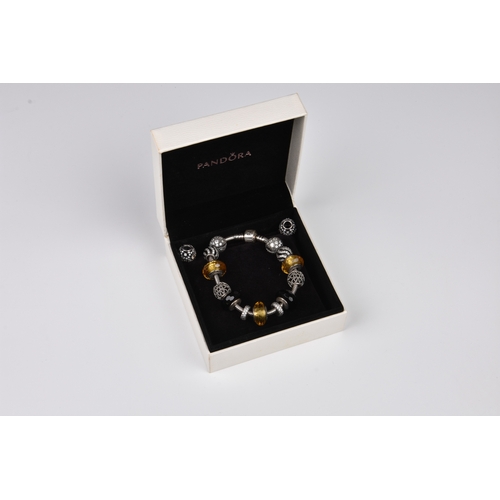 696 - A Pandora bracelet with eleven silver charms in silver, black and amber tones, most set with crystal... 