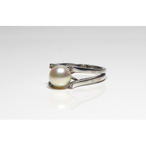 771 - A 14ct white gold, pearl and diamond ring the 8mm cultured pearl over bifurcated shoulders, accented... 