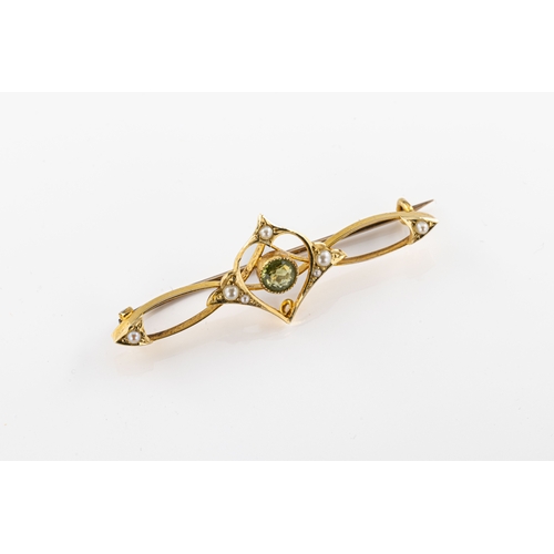 779 - A peridot and seed pearl brooch The pendant brooch with a central peridot mounted in yellow metal, a... 