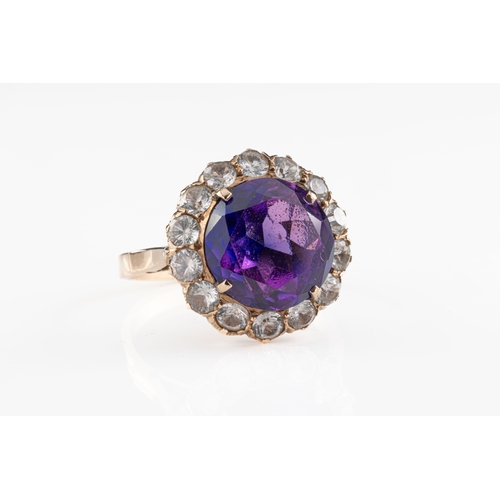 789 - An amethyst and spinel cluster ring The central amethyst claw set within a cluster surround of fifte... 