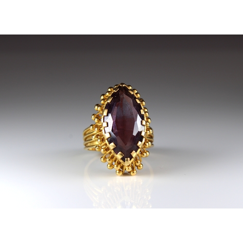 807 - A 22ct yellow gold and alexandrite ring The marquise shaped claw-set purple stone within a 22ct yell... 