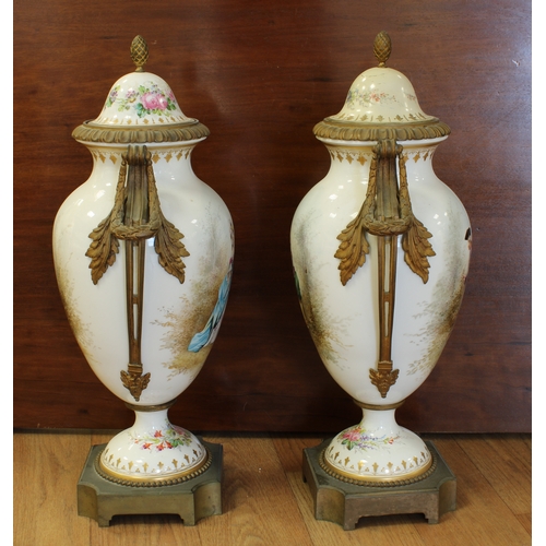 70A - A pair of Sevres style porcelain urn shaped lidded vases ormolu mounted, hand painted with elegant f... 