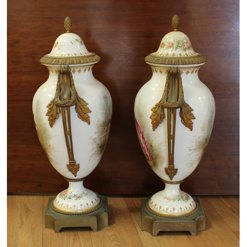 70A - A pair of Sevres style porcelain urn shaped lidded vases ormolu mounted, hand painted with elegant f... 