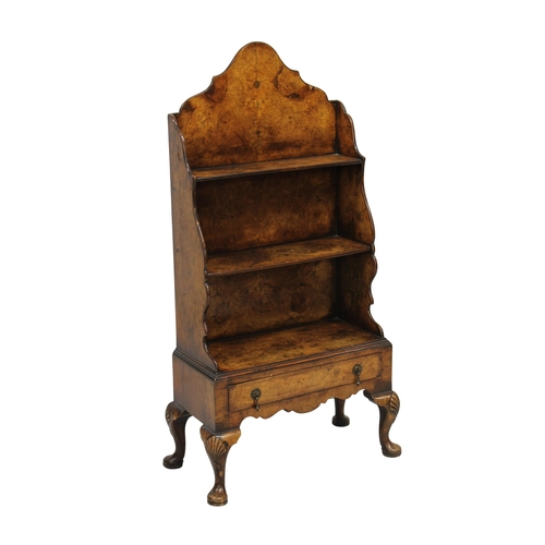 184 - A 1930's burr walnut waterfall bookcase on stand with three shelves over a single drawer, on cabriol... 