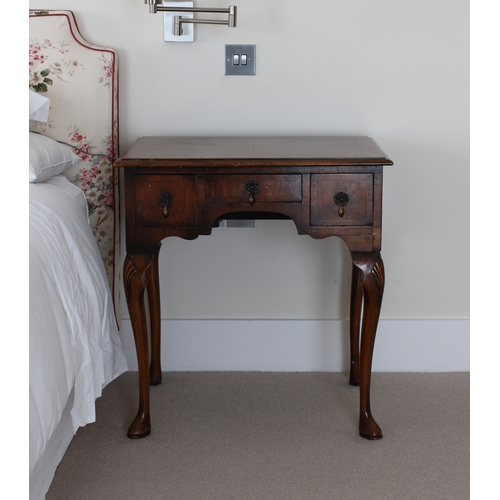 186 - A 1920's/1930's walnut lowboy the crossbanded rectangular top over three frieze drawers with drop ha... 