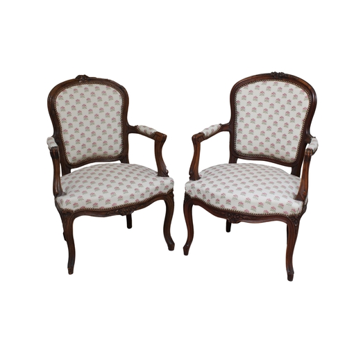 196 - A pair of Louis XV style carved beechwood fauteuils early 20th Century, with a foliate crested top r... 