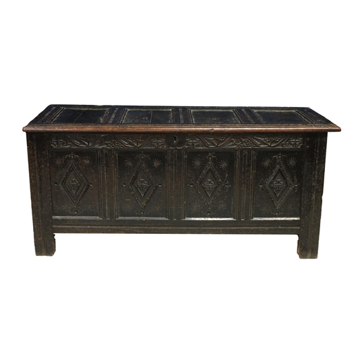 225 - A 17th century oak coffer the four panel top with carved 'SW' opening to a lined interior, over a to... 