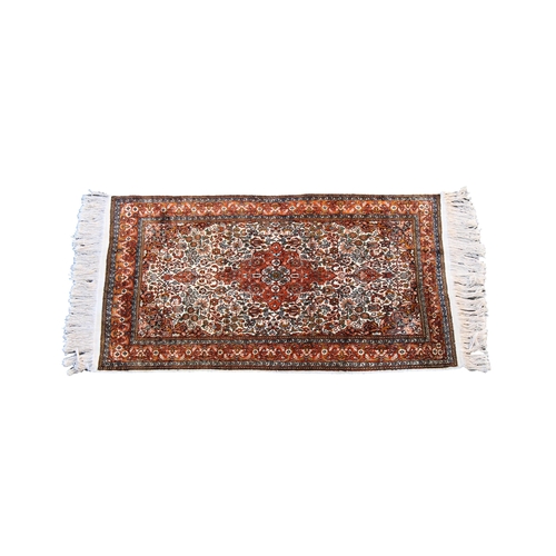 251 - A small Kashan style silk rug the central floral medallion with matching spandrels on an ivory groun... 