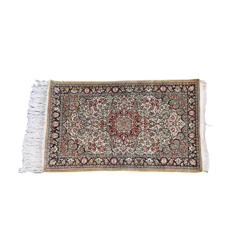 256 - A silk Qum rug with a central medallion on an ivory ground with floral fillers, flanked by meanderin... 