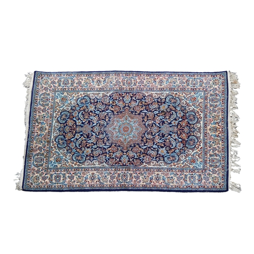 257 - A small silk fringe Isfahan rug with a central medallion on a blue floral field, flanked by meanderi... 