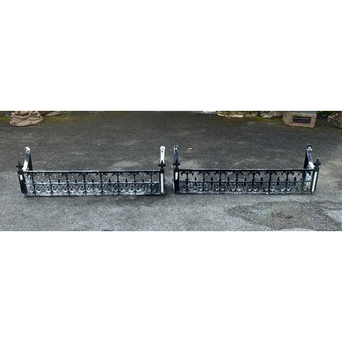 286 - A pair of black painted metal plant pot / trough holders for window sill having ornate pierced desig... 